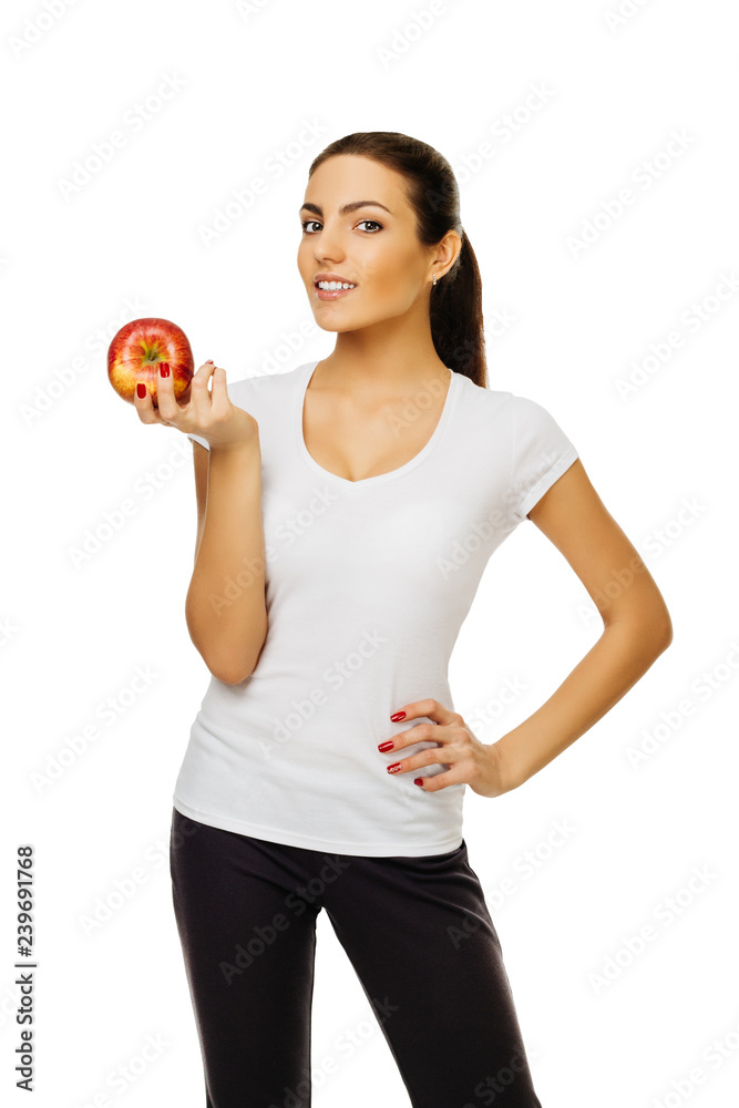 beautiful young happy brunette woman in white t-shirt holds apple. stands posing smiling on white background isolated beautiful young happy brunette woman in white t-shirt holds apple. stands posing smiling on white background isolated