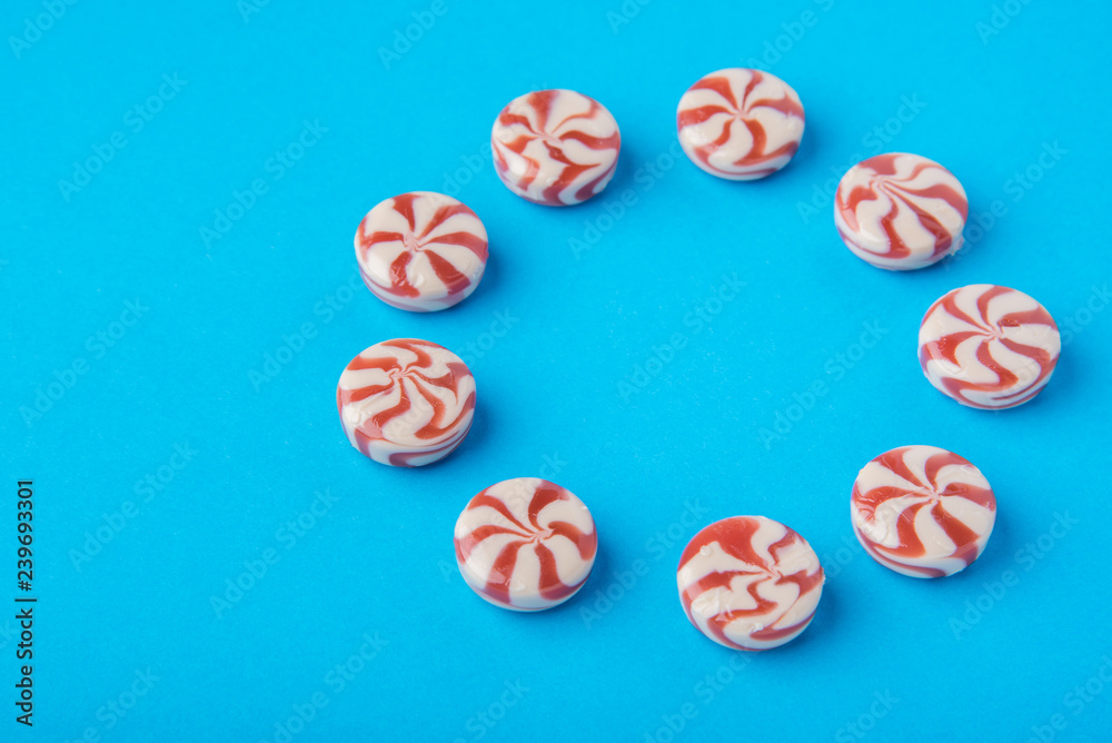 Round candy red and white on a blue background