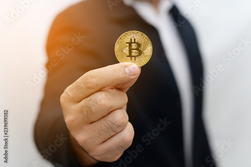 Business man hand holding bitcoin cryptocurrency soft focus background