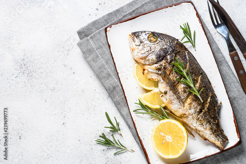 Canvas Print Baked dorado fish with lemon and rosemary top view.
