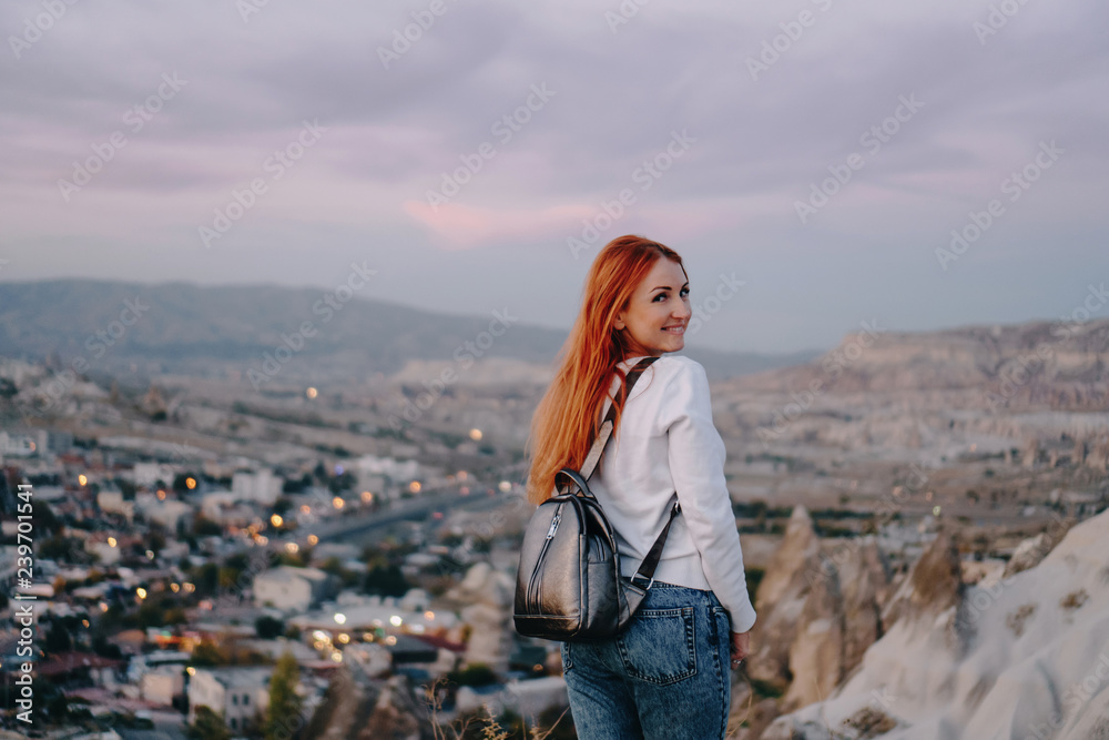 young woman tourist stands against mountain landscape young woman tourist stands against mountain landscape