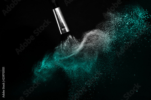 Deep ocean powder color splash and silver brush for makeup artist or beauty blogger in black background, look like a look like a cold and calm mood.