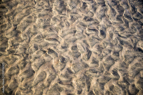 Natural textured background of wave patterns left at low tide in silky sand in a full frame abstract close up