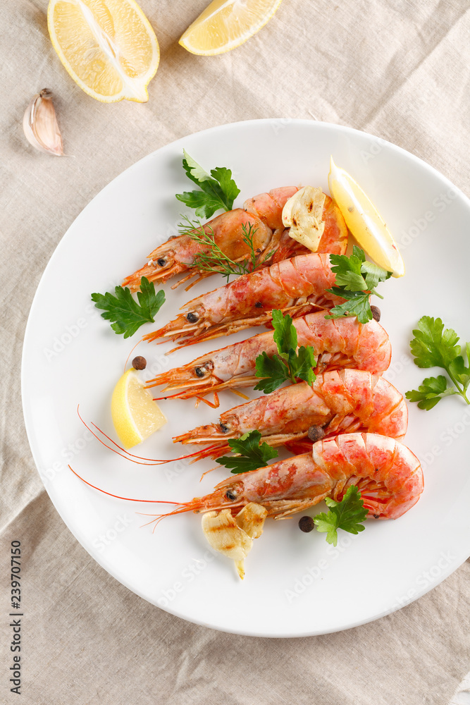 Grilled shrimps with spice, lemon and greenery. Grilled seafood. Top view.