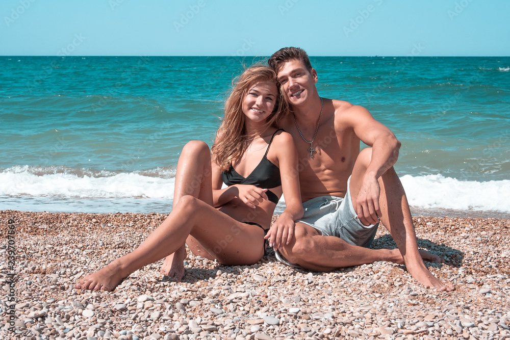 Romantic couple sitting on the sand at the beach