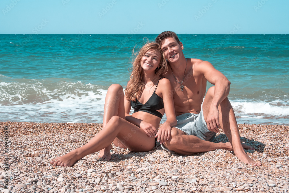 Romantic couple sitting on the sand at the beach