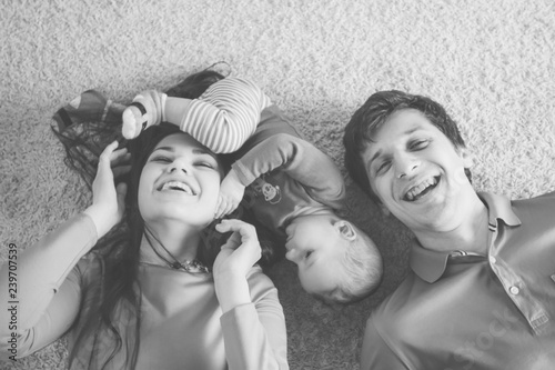 Cheerful happy family and their little son. Little boy plays with mom's hair. Funny family time. New Year Time. Christmas decoration.