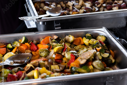 Obraz na plátně Fresh grilled vegetables in hot buffet tray with closeup of spoon to serve food