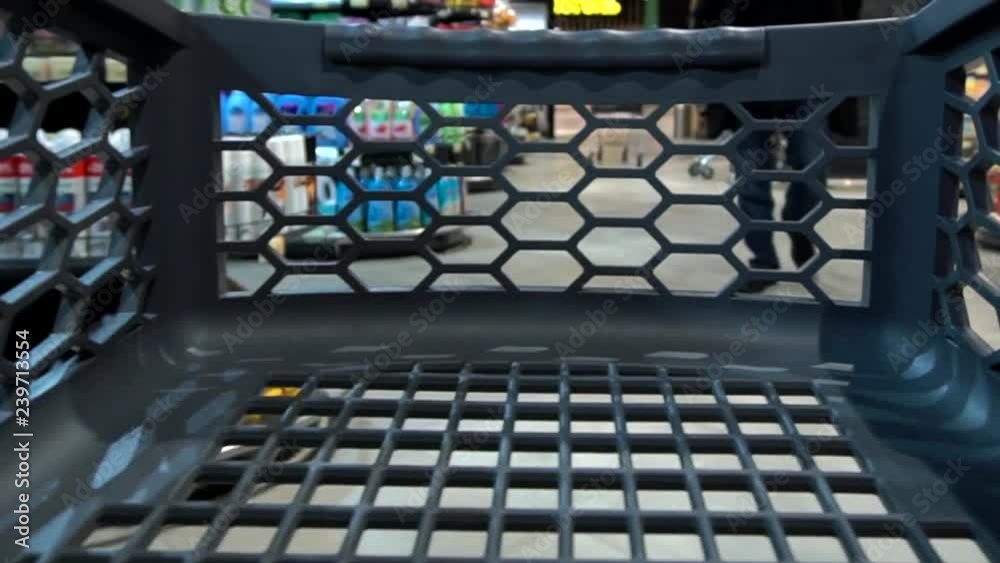 Empty shopping cart quickly rides in a grocery store. View from a shopping cart trolley into supermarket, close-up. Shopping tour in a grocery shop with winter holidays decoration. Empty shopping cart quickly rides in a grocery store. View from a shopping cart trolley into supermarket, close-up. Shopping tour in a grocery shop with winter holidays decoration.
