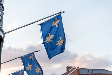 New Orleans old town street in Louisiana famous town, city, fleur-de-lis blue flags hanging off balcony wall, nobody at dark evening sunset, architecture, sunrise in sky