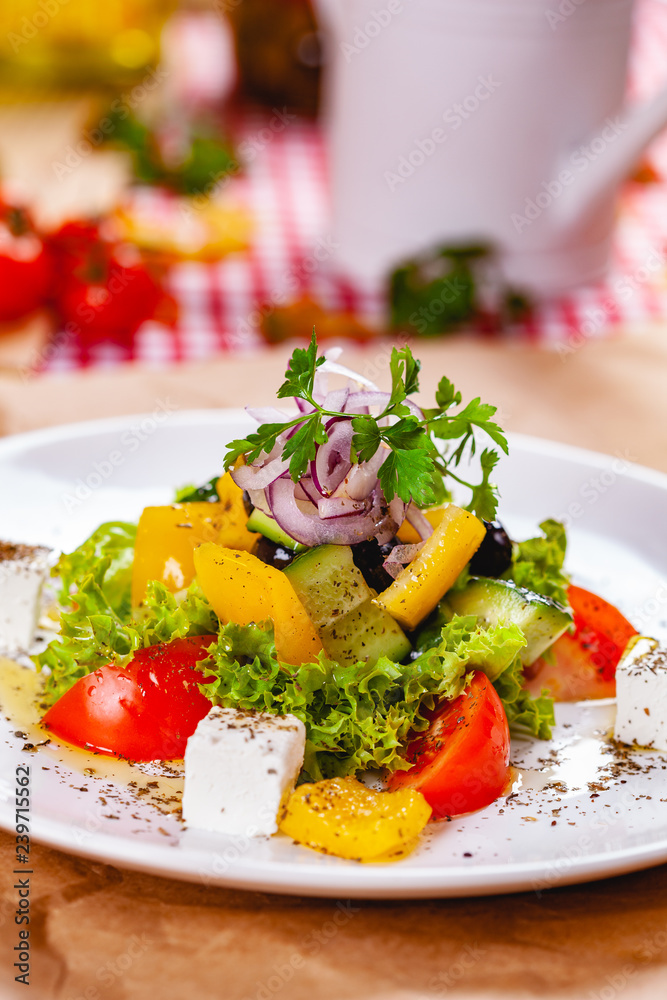 Greek salad with vegetables and feta cheese on white plate. Close up Greek salad with vegetables and feta cheese on white plate. Close up