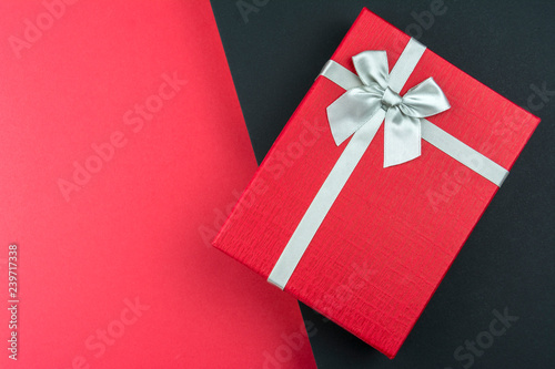 Red gift box with bow on black and red background