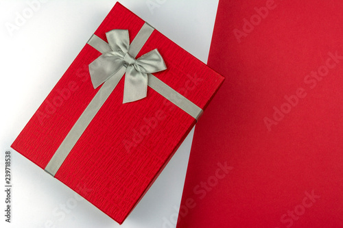Red gift box with bow on red and white background