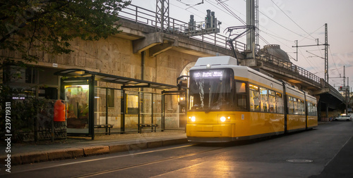 Public transportation concept. Yellow electric tram at Berlin, Germany. Cloudy sky background. photo