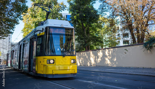 Public transportation concept. Tram yellow, modern, electric at Berlin, Germany. City and nature background.