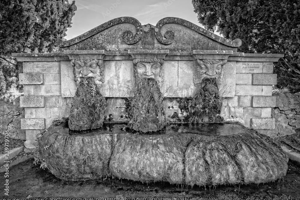 Fototapeta premium Fontaine de Lourmarin. The fountain with three masks in Lourmarin, Provence, Luberon, Vaucluse, France