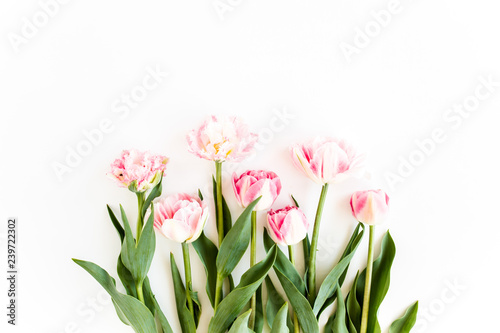 Fototapeta Naklejka Na Ścianę i Meble -  Pink tulips on white background. Minimal floral concept greeting card. Flat lay, top view.