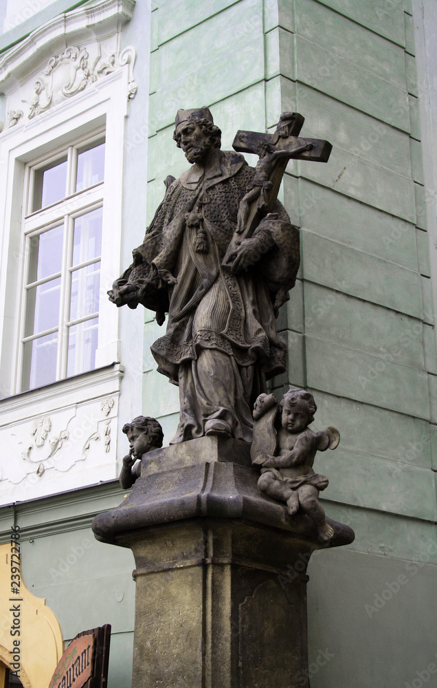 Statue of old priest with cross and Jesus at Old Town in Prague, Czech Republic, close up, details Statue of old priest with cross and Jesus at Old Town in Prague, Czech Republic, close up, details