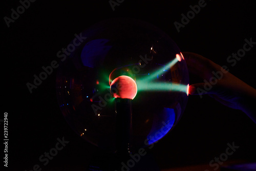 Plasma ball lamp energy, hand touching glowing glass sphere concept for power, electricity, science and physics