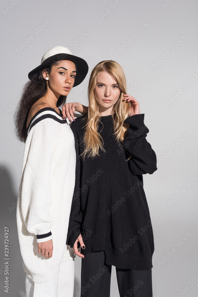 attractive multicultural female models in black and white clothes standing and looking at camera on white attractive multicultural female models in black and white clothes standing and looking at camera on white