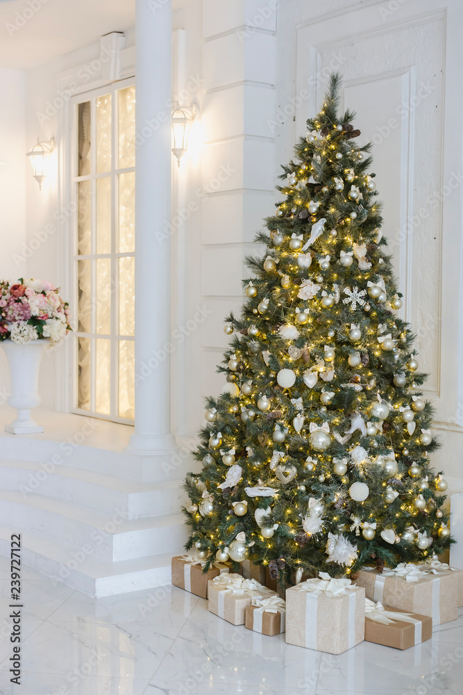 Christmas tree with garlands, lanterns, gifts, gold and red balls in the light room
