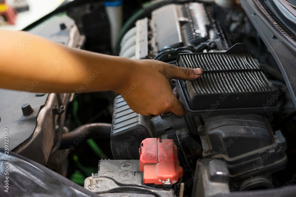 custom made wallpaper toronto digitalAn auto mechanic wearing protective work gloves holds a dirty, clogged air filter over a car engine during general auto maintenance.
