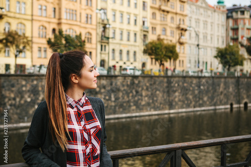 Portrait of a young beautiful girl on the street of Prague. Lifestyle. In the background is the architecture of Prague.