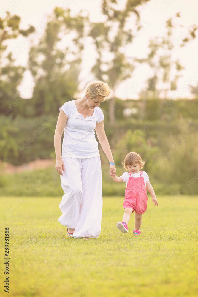 Fototapeta premium mother and little daughter playing at backyard