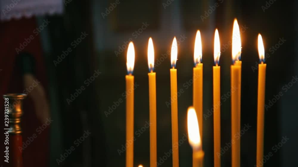 row of orange burning candles in the church, close up row of orange burning candles in the church, close up