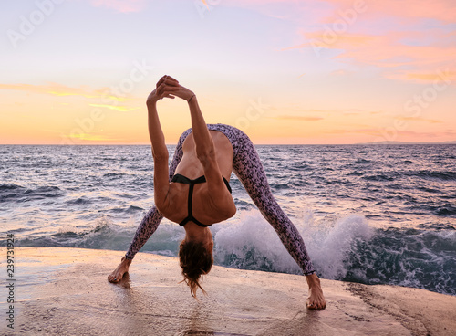 Flexible female bending forward near sea
