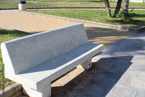White stone bench and green space