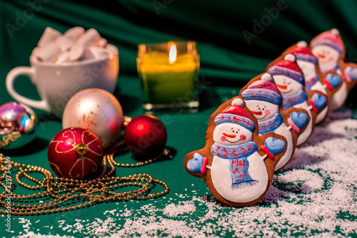 Congratulatory background with christmas-world cookies in the form of snowmen as a symbol of the new year 2019 with New Year's toys and a candle (greeting card, greetings - concept)