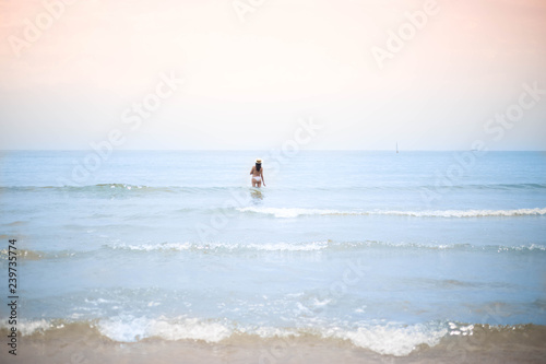 mujer bañándose en el mar con sombrero de paja