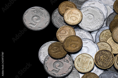 Ukrainian coins isolated on black background. Close-up view. Coins are located at the right side of frame. A conceptual image.