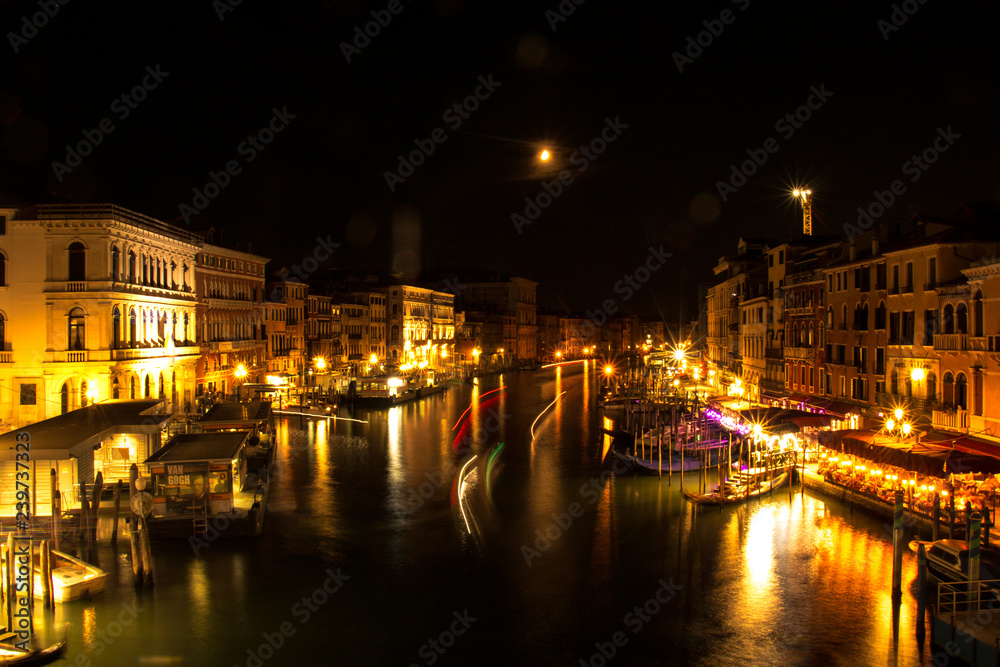 Venice bridge with grand canal views in night.