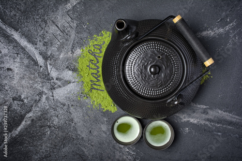Top view on organic green matcha tea with traditional black asian kettle