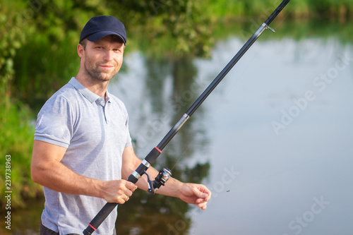 Portrait of fisherman with fishing rod on lake.