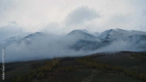 Wallpaper Mural Scenic Aerial drone shot of forest valley and snowy mountains range landscape through low cloud. Altai evening rocks in clouds. Inspirational, Motivational Nature view. Torontodigital.ca