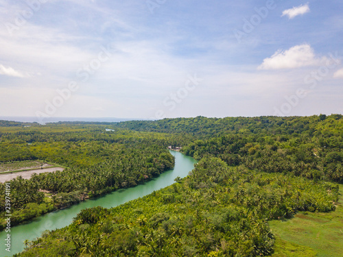 Aerial drone view to Loboc river. Mountain river flows through green forest. Bohol island, Philippines