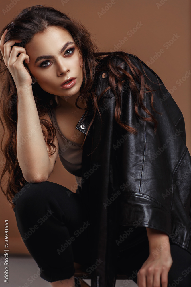 Fototapeta premium Young beautiful woman in a black jacket