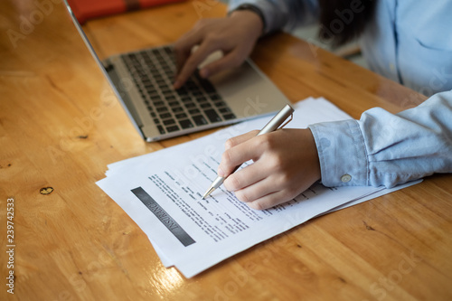 Sit in office laptop, Attractive young female insurance agent working with laptop and insurance document paper.