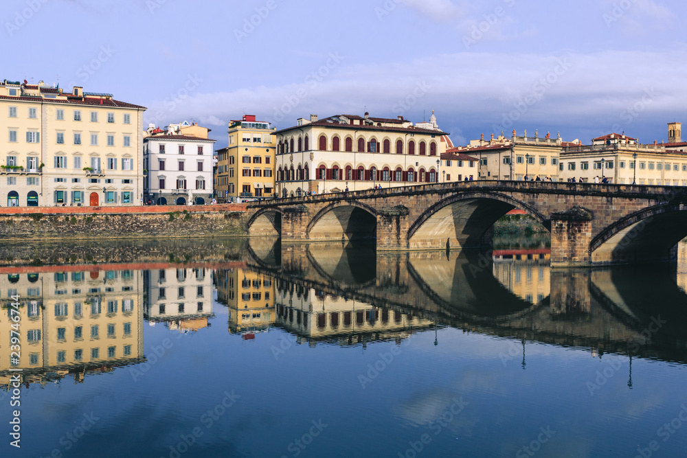 Old buildings reflecting in the Arno River in Florence. Houses with reflection in water