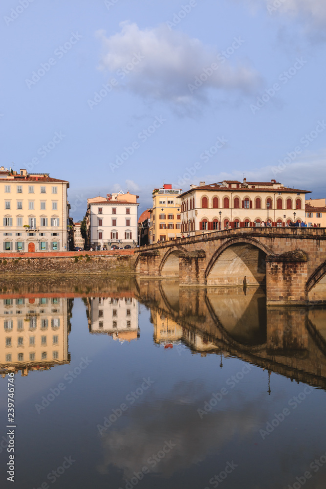 Old buildings reflecting in the Arno River in Florence. Houses with reflection in water