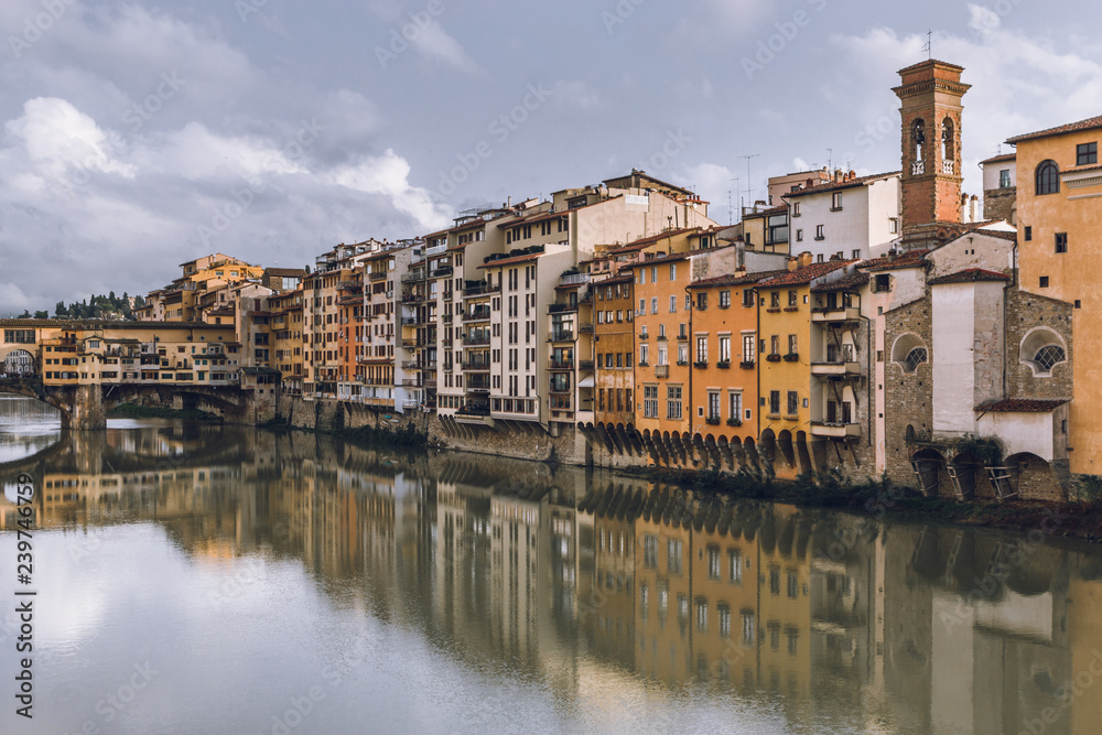 Old buildings reflecting in the Arno River in Florence (Firenze). Houses with reflection in water