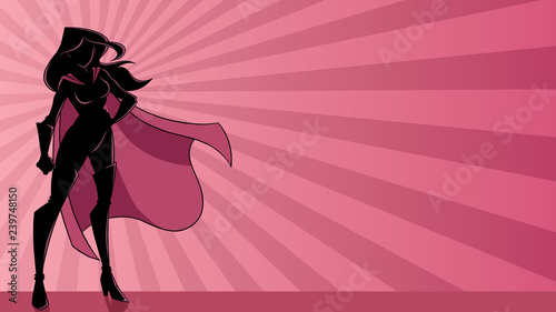 Full length illustration of determined and powerful superheroine wearing cape while standing tall against abstract ray light background.