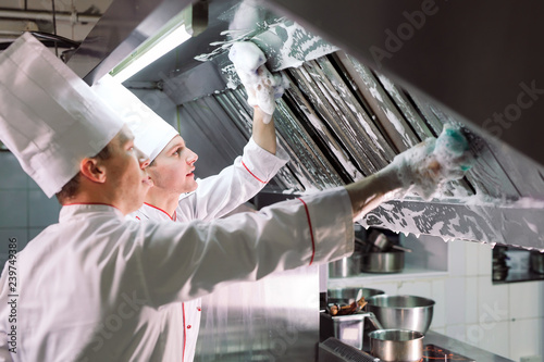 Sanitary day in the restaurant. Repeats wash your workplace. Cooks wash oven, stove and extractor in the Restaurant. photo