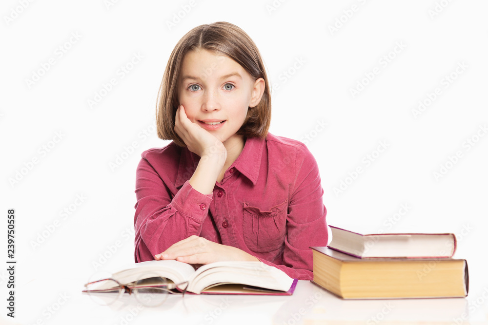 Beautiful teen girl sitting at a table with books, white background Beautiful teen girl sitting at a table with books, white background