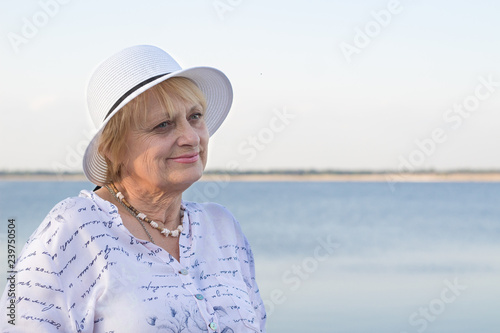 Happy retired woman rests in nature near sea