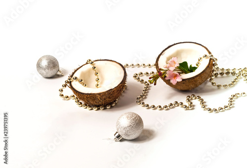 Creative layout of coconuts, concept of New Years holiday.Decorative Garland and silver balls on pink background, Christmas decor 