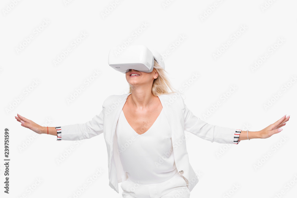 Blond woman in white suite with virtual reality goggles. Studio shot on white background Blond woman in white suite with virtual reality goggles. Studio shot on white background